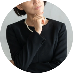首をかしげる喪服の女性イメージ画像
